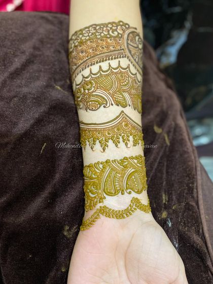 The design progresses down the arm, adding more layers and patterns.