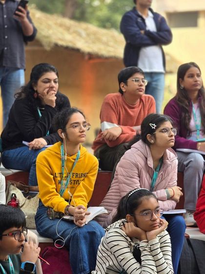 Students look on with concentration during an outdoor art lesson, fully engaged in the learning process.