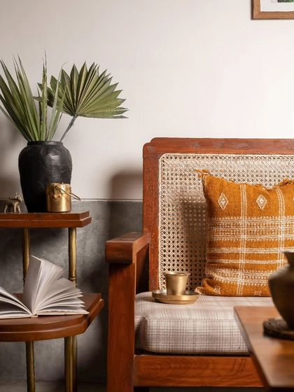 This detail shot highlights the material palette of the living room, with warm wood, natural cane, and touches of brass creating an earthy and inviting atmosphere.