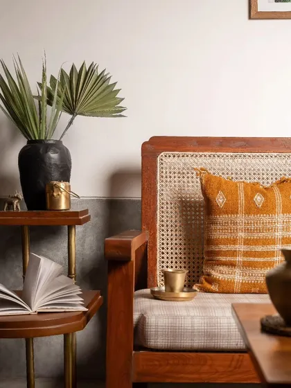 This detail shot highlights the material palette of the living room, with warm wood, natural cane, and touches of brass creating an earthy and inviting atmosphere.
