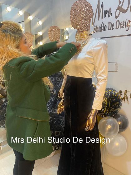 Here I am styling a mannequin in a chic, Bollywood-inspired outfit. The ensemble features a classic white long-sleeve top paired with a black velvet skirt and a statement gold neckpiece, a look that is both timeless and modern.