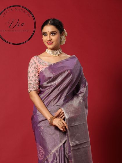 A portrait from a campaign shoot. This look features a classic South Indian bridal style with a pearl choker, a simple bun adorned with flowers, and clean, elegant makeup.