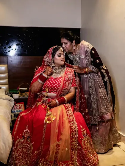 A tender and emotional moment between the bride and her mother. As her mother gives her a kiss and helps with her final touches, this photo captures the deep love and connection that is so central to the wedding day.
