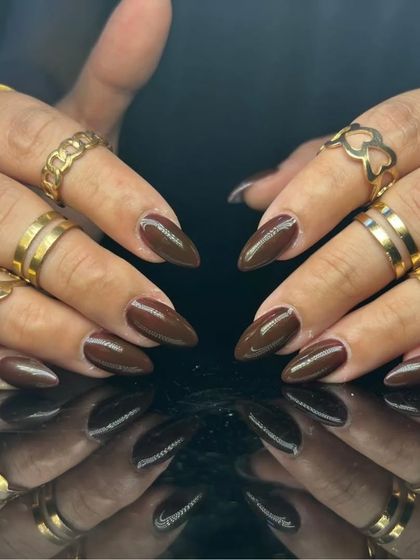A complete view of the elegant dark brown manicure.