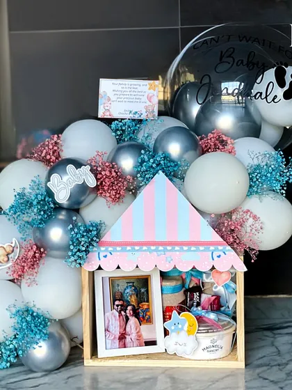 A perfect gift for parents-to-be. This house-shaped hamper holds a precious photo frame for their memories, along with treats and gifts to celebrate their exciting journey ahead.