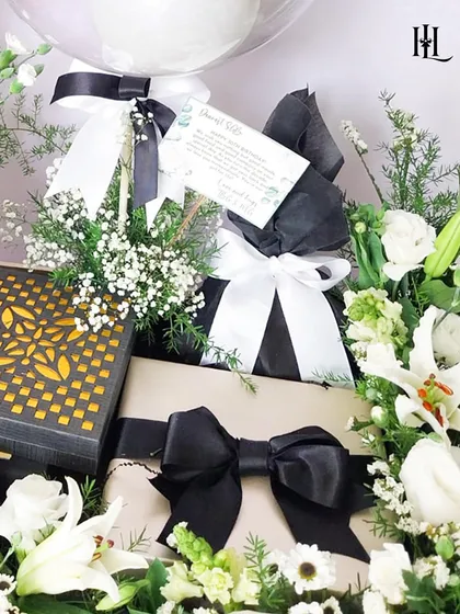 Celebrating a 30th birthday milestone calls for a touch of monochrome elegance. This hamper features gifts wrapped in black and white, surrounded by fresh white lilies and baby's breath. It's a chic and sophisticated arrangement perfect for personal or corporate milestones.