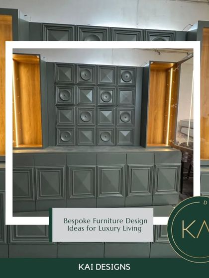 This bold, architectural storage unit in a dark grey finish features geometric paneling and two illuminated display niches with a gold-leaf-style backing. It's a dramatic and highly functional statement piece.