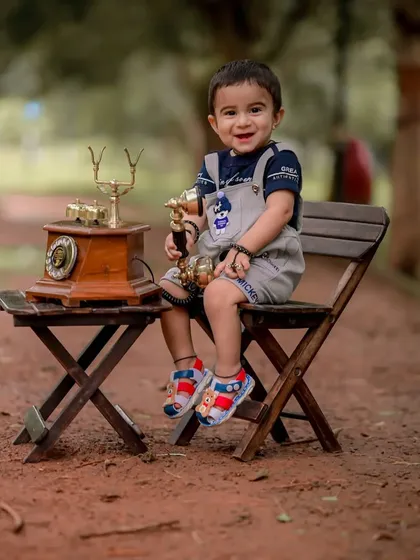 This little one is all smiles, holding the receiver like a trophy. These playful interactions are the heart of a successful and fun baby photoshoot.
