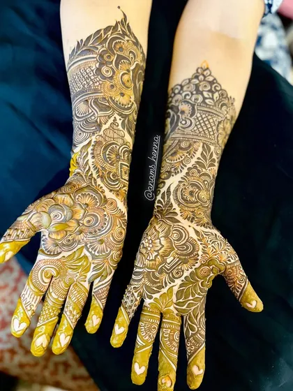 A stunning pair of bridal hands with matching intricate designs. The patterns are a mix of Pakistani and Indian styles, with lots of fine detail work.