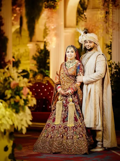 A regal portrait of the bride and groom in their heavily embroidered wedding outfits.