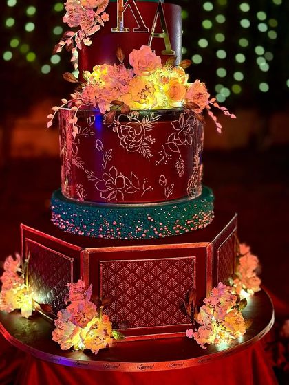 A detailed shot of the hand-painted floral patterns and the glowing sugar flowers on this wedding cake.