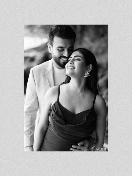 A classic black and white portrait of the couple, her smile radiant as he holds her from behind.