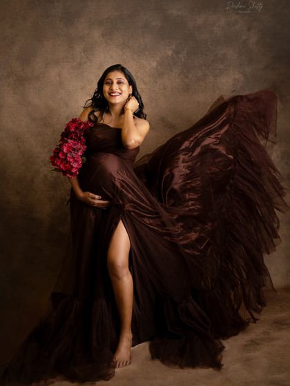 The joy is palpable in this shot. A laughing mom-to-be, with her brown gown flowing around her, creates a dynamic and beautiful image full of life and happiness.