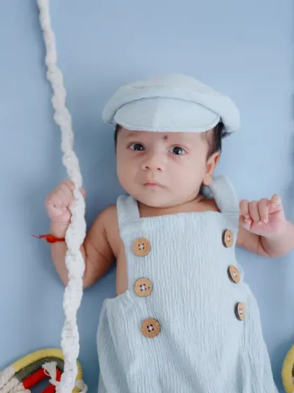 A close-up shot of the newborn on the swing, highlighting his sweet expression and the soft textures of the setup.
