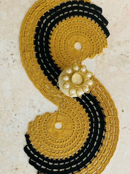 The gold and black spiral runner styled with a decorative candle holder.