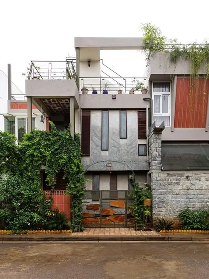 Here is the exterior of the same residence, showcasing how the interior's complexity is expressed on the facade. A mix of stone, wood, and glass is softened by cascading greenery, allowing the building to settle into its natural surroundings rather than impose on them.