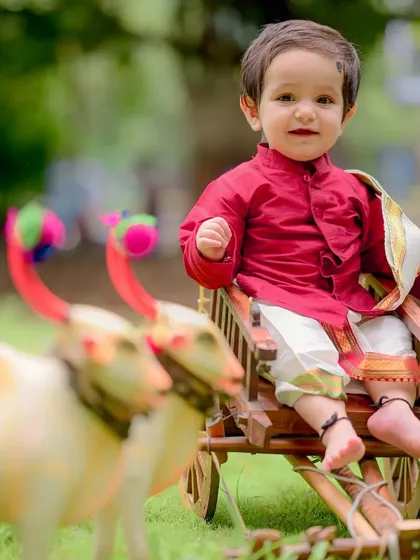 Dressed in a vibrant red silk kurta, little Charul looks like royalty on the mini bullock cart. These traditional outfits add so much richness and meaning to a child's portrait session.
