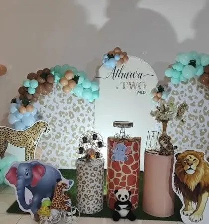 A "Two Wild" birthday theme with a cheetah-print backdrop and cutouts of various safari animals like a cheetah, lion, and elephant.