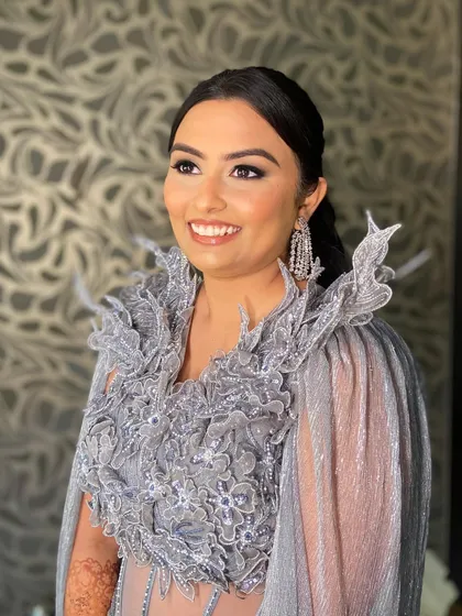 The perfect party look. Bansi's makeup is glamorous yet sophisticated, complementing her high-fashion outfit.