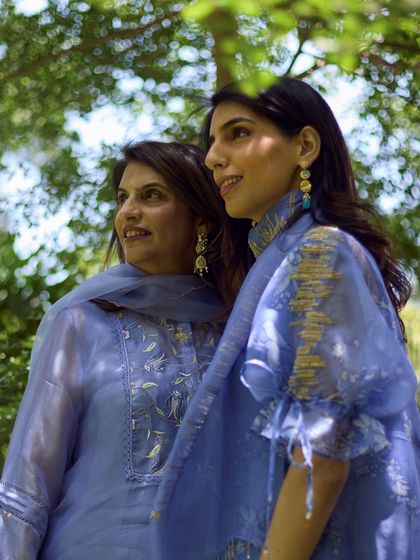 Another beautiful mother-daughter moment, showcasing how different earring styles can complement a coordinated color palette for a family event or festival.