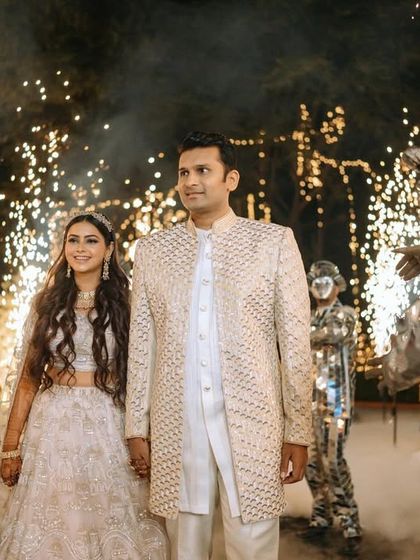 A grand entrance with sparklers and mirror-costumed performers, setting a spectacular tone for the Sangeet night.