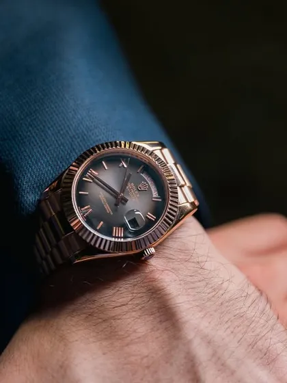 A detail shot focusing on the groom's luxurious Rolex watch, an important accessory for his wedding day look.