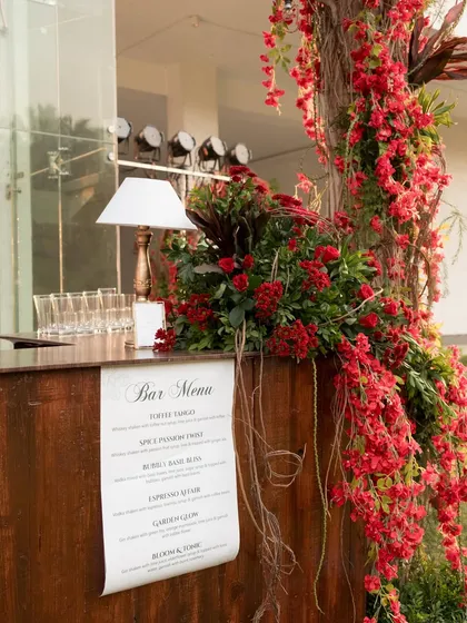 The outdoor bar was decorated with a cascade of red flowers, seamlessly blending it into the garden party theme.
