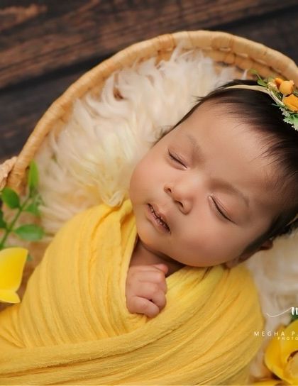 This angle captures the baby's profile and the texture of the yellow wrap and the basket.
