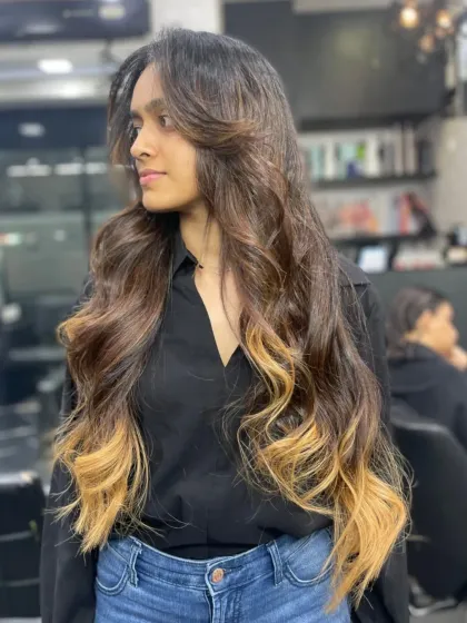 This is a perfect example of a dramatic yet wearable look. We created a beautiful ombre effect, transitioning from a natural dark root to bright blonde ends on very long hair. The result is a high-impact style with seamless blending.