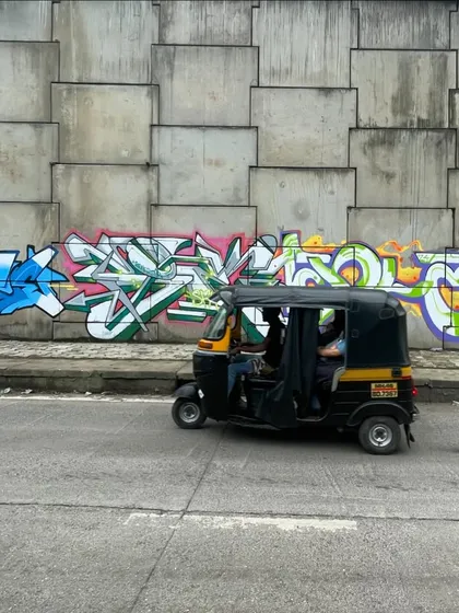 An auto-rickshaw passing by the Hindi "Krypt" piece. This is what street art is about, becoming part of the city's daily life and landscape.