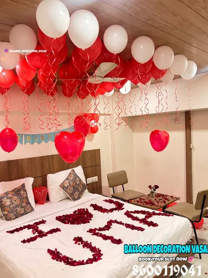 Another angle of the personalized room decoration, showing the density of the ceiling balloons with hanging ribbons and the small table set for two, ready for a private celebration.