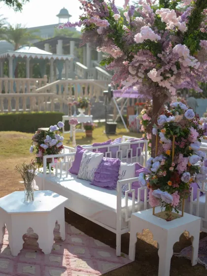 A detailed shot of the white and lavender lounge seating. The custom pillows and elegant furniture are all part of the cohesive design language for the event.