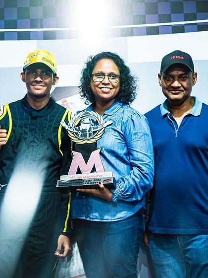 A driver celebrating his vice-championship trophy with his family.
