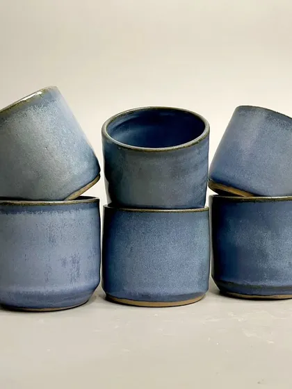 A set of my ceramic tumblers in a beautiful, rustic blue glaze. These mugs are not just vessels; they are conversation starters that add a dash of whimsy to your daily routine.