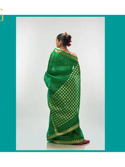 Another angle of the shamrock green saree from the back, emphasizing its vibrant color and luxurious texture.