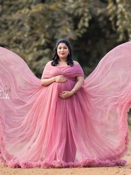 The flowing pink gown creates a stunning butterfly effect in this magical outdoor portrait.