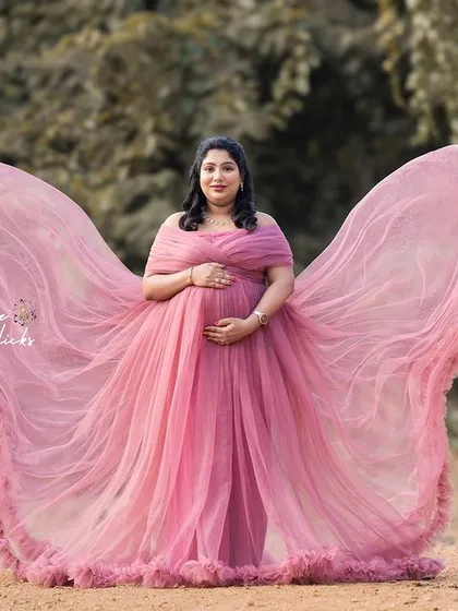The flowing pink gown creates a stunning butterfly effect in this magical outdoor portrait.