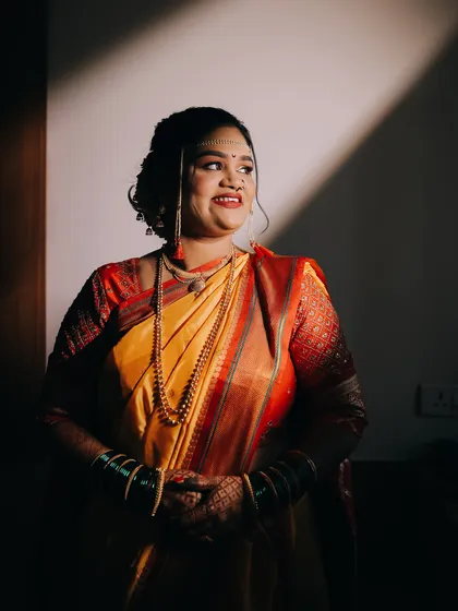 A candid moment of a Maharashtrian bride, beautifully lit by a ray of sunlight. These unposed shots often reveal the most genuine emotions of the day.