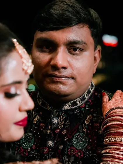 A close-up portrait focusing on the groom's expression as he stands by his bride.