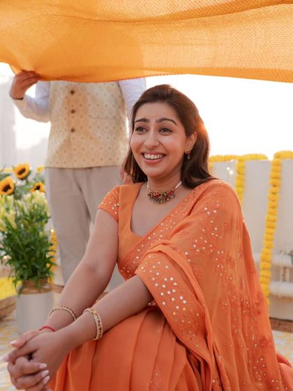 The bride's happy and serene expression just before her Haldi ceremony begins, bathed in the warm glow of the sun.