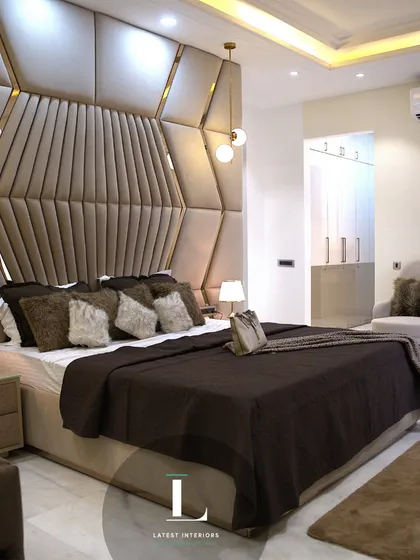 I believe a bedroom should be a personal sanctuary. This master suite features a dramatic, custom-designed geometric headboard in plush, warm tones, creating a focal point that is both luxurious and inviting.
