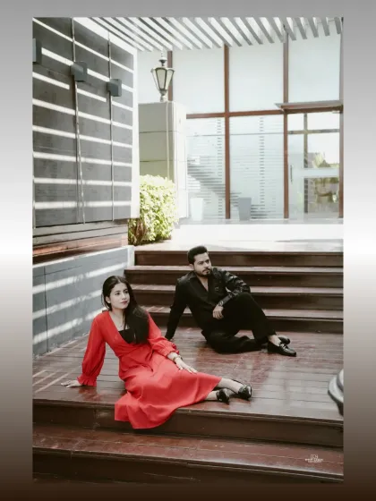 A stylishly composed shot of the couple relaxing on a modern staircase, using interesting angles and shadows for a high-fashion look.