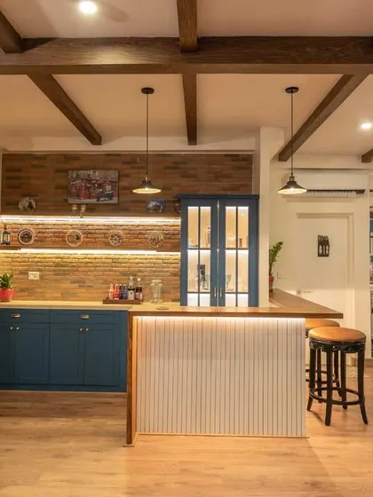 An industrial-style mini-bar designed for entertaining. We used a brick-clad wall, dusty blue cabinets, and a solid wood countertop to create a stylish and functional space for mixing drinks and hosting friends.
