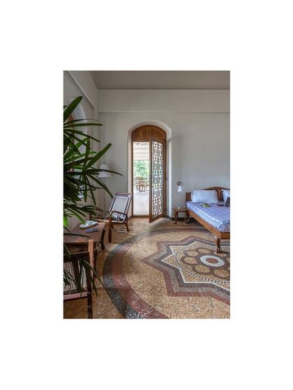 This bedroom view highlights the seamless integration of restored flooring, salvaged wood furniture, and newly designed doors that honor the building's original aesthetic.
