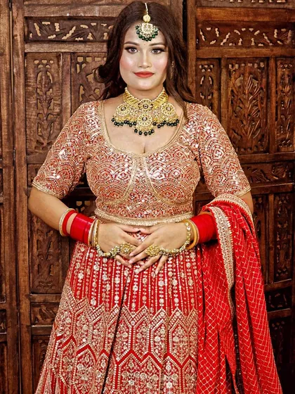This bright red lehenga with silver and gold sequin work is a fantastic choice for a modern bride who still loves the traditional red. It's paired here with a green enamel jewellery set.