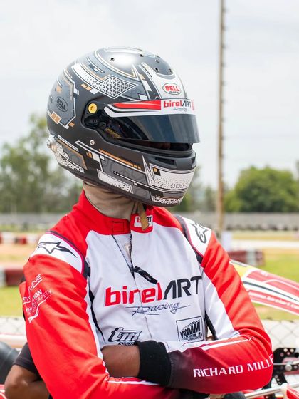 A portrait of our driver Abhay in his racing gear, showcasing the professional equipment and focused mindset of a Birel ART racer.