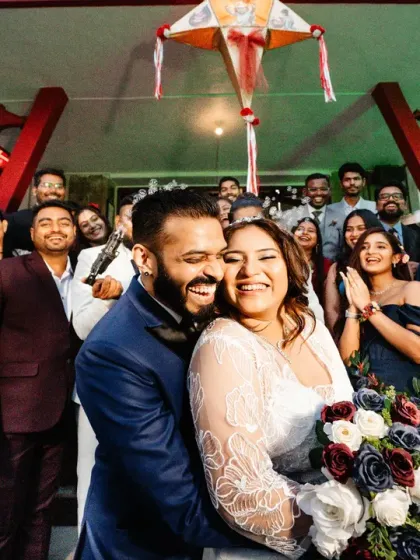 A happy group photo outside the reception venue. The couple is embraced by their loved ones, all sharing in the joy of the day.