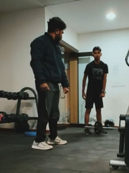 Another moment from a home training session. Here, I'm instructing a client on the proper form for a deadlift with a light barbell, proving you can build strength anywhere.