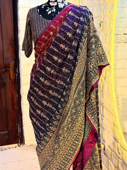 A detailed shot of the 'ROOP' saree's pallu. The heavy embroidery adds a touch of royalty, making it perfect for weddings and grand celebrations.