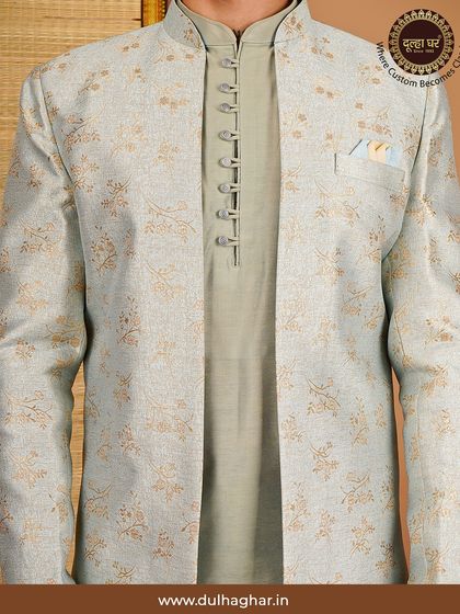 A close-up of a layered Indo-Western look, featuring a light grey floral jacket over a sage green kurta with intricate button details.